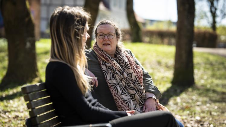Behandler taler med en ung pige på en bænk
